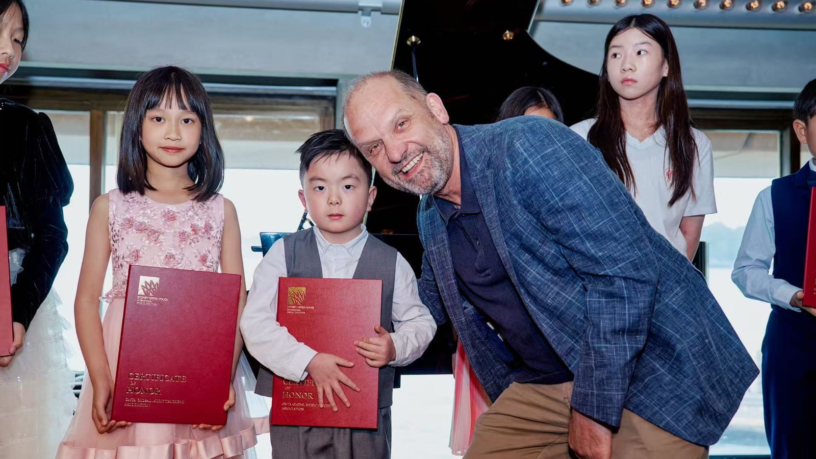 Festival award ceremony with artistic leadership and young participants holding certificates