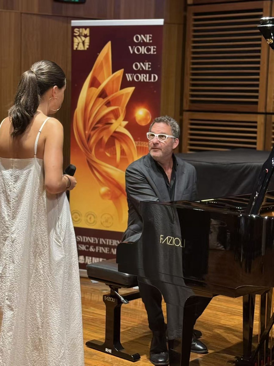 Vocalist and pianist during a Festival performance with Festival banner